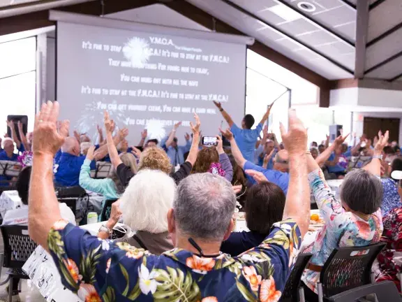 group with arms raised from behind 