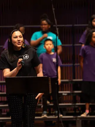 Georgina Chincilla Gonzalez with childrens chorus behind her