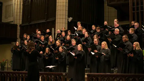 National Lutheran Choir singing as a group with director in front of them