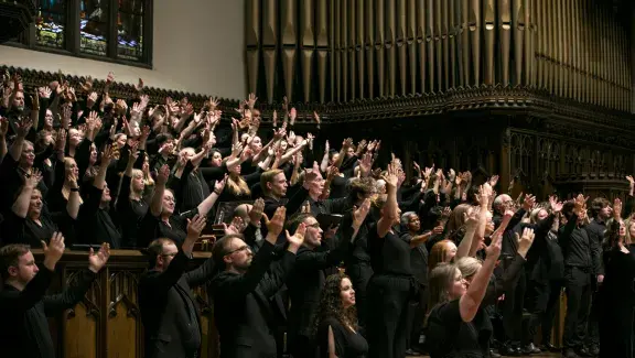 choir raising their hands in song