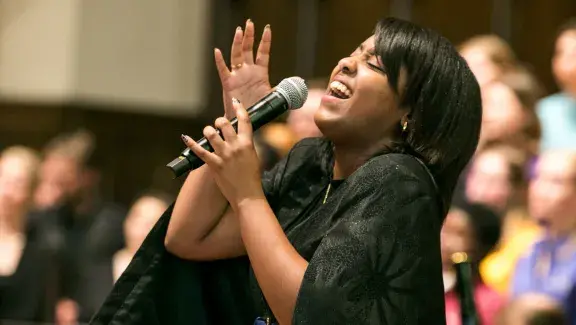 Woman singing and looking up with closed eyes